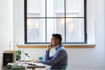 Man sat at a desk working on a laptop
