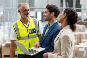 Two consultants chatting and smiling with warehouse manager