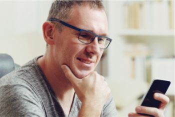 Man with a hearing impairment looking at a mobile device
